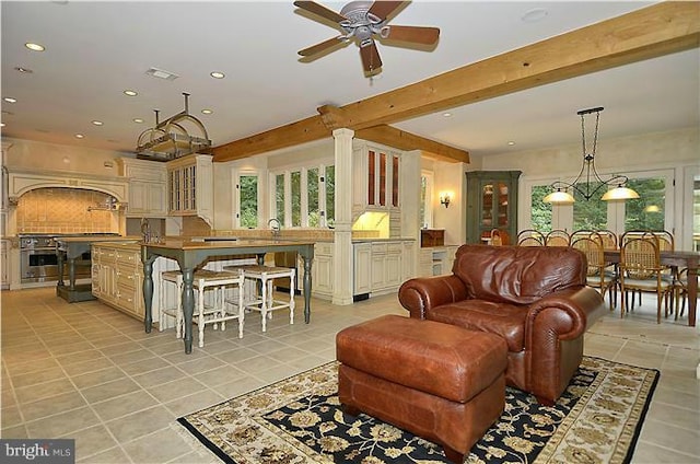 living area with plenty of natural light, a ceiling fan, and light tile patterned floors