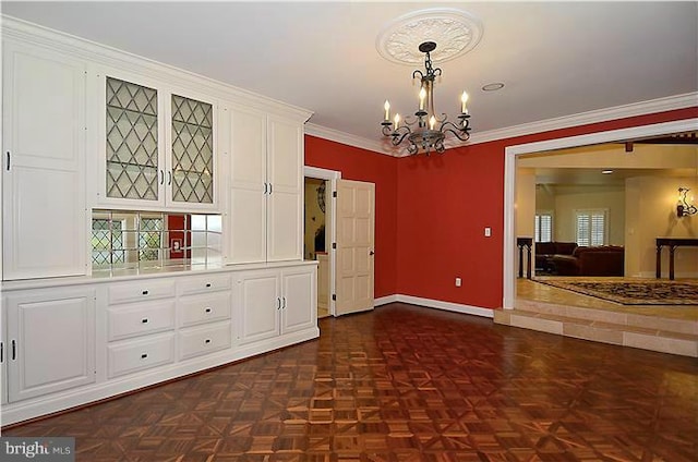 unfurnished dining area featuring crown molding, baseboards, and an inviting chandelier