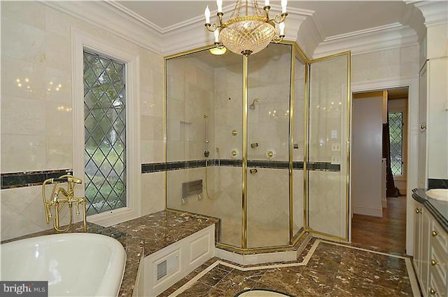 full bathroom with crown molding, an inviting chandelier, vanity, a bath, and a stall shower
