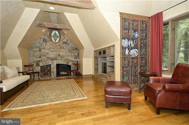 living room with a stone fireplace, wood finished floors, high vaulted ceiling, and beamed ceiling