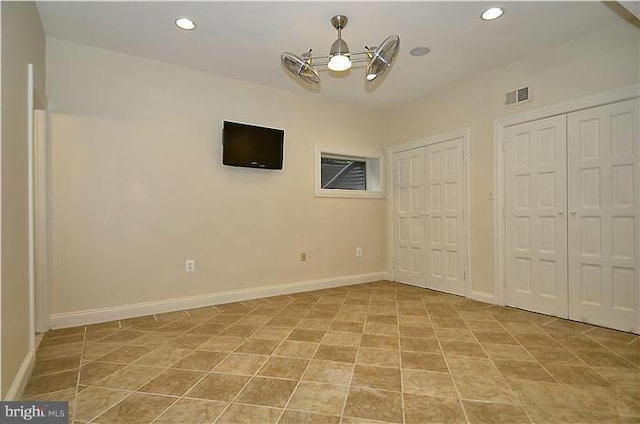unfurnished bedroom featuring visible vents, baseboards, a chandelier, multiple closets, and recessed lighting