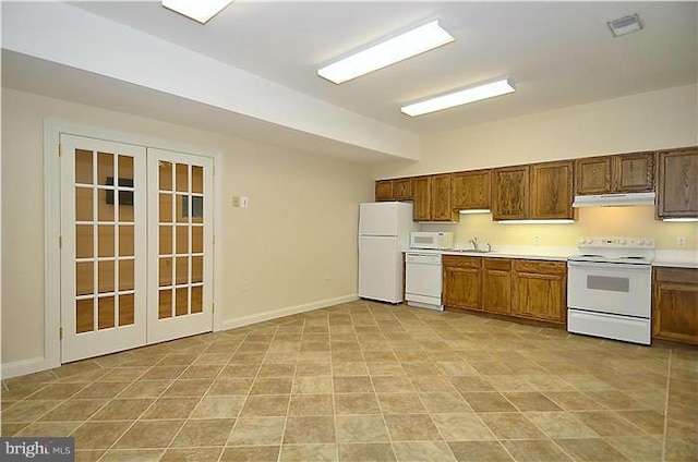 kitchen with visible vents, white appliances, baseboards, light countertops, and under cabinet range hood