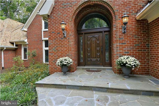 view of exterior entry featuring brick siding