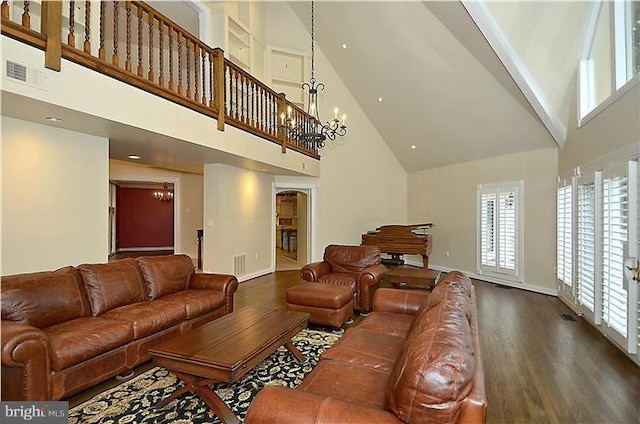 living room with visible vents, wood finished floors, baseboards, high vaulted ceiling, and a chandelier