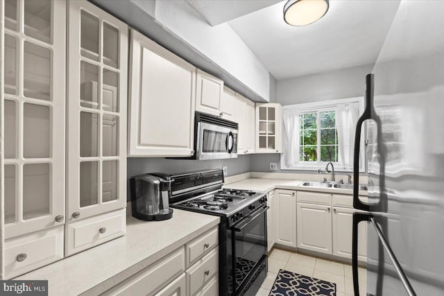 3128 Martha Custis Dr, Alexandria, VA 22302 - kitchen featuring stainless steel appliances, a sink, light tile patterned floors, glass insert cabinets, and light countertops
