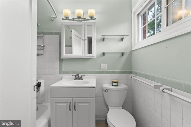 3128 Martha Custis Dr, Alexandria, VA 22302 - bathroom featuring tile walls, toilet, vanity, a wainscoted wall, and tub / shower combination