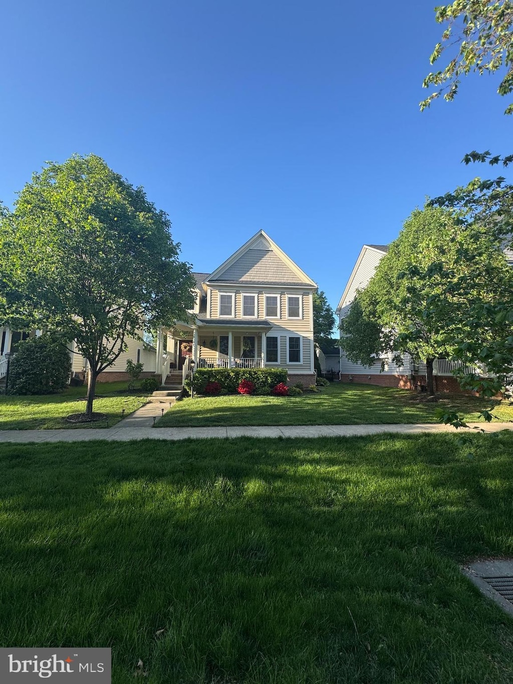 view of front of home with covered porch and a front lawn
