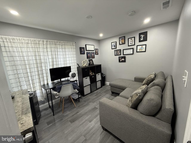 interior space with baseboards, recessed lighting, wood finished floors, and visible vents