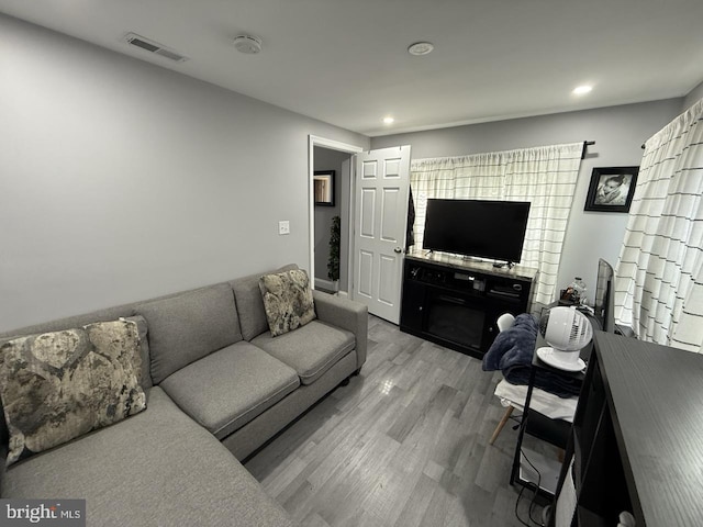 living room with visible vents, recessed lighting, and light wood-style flooring
