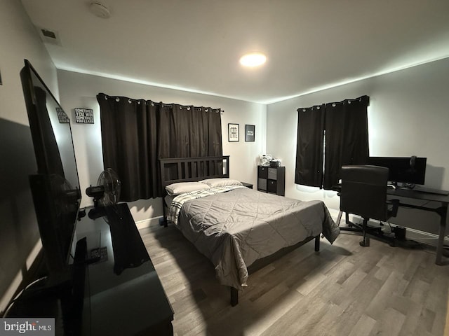 bedroom featuring baseboards and wood finished floors