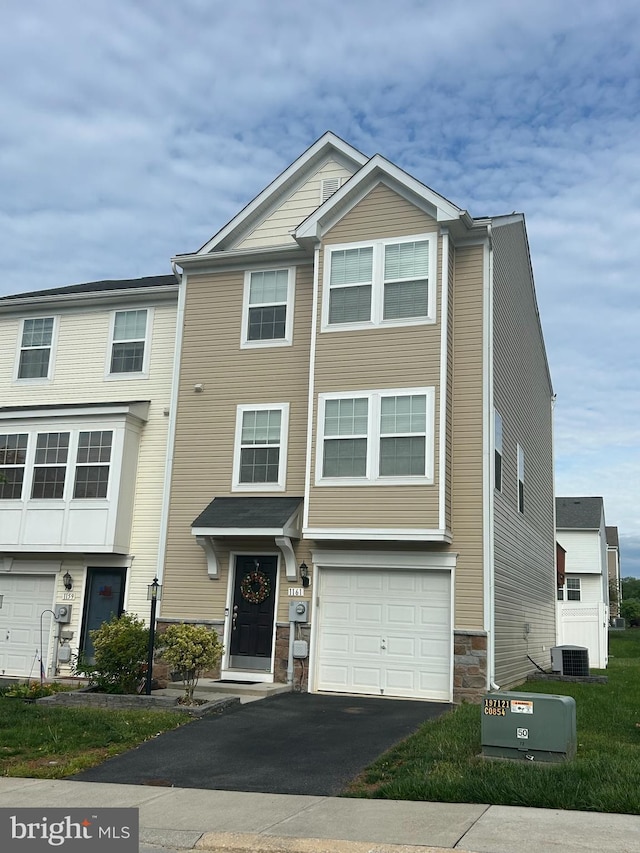 1161 Steed St, Ranson, WV 25438 - view of front facade with driveway, stone siding, a garage, and central AC unit