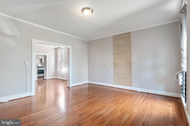 unfurnished room with wood-type flooring, baseboards, and ornamental molding