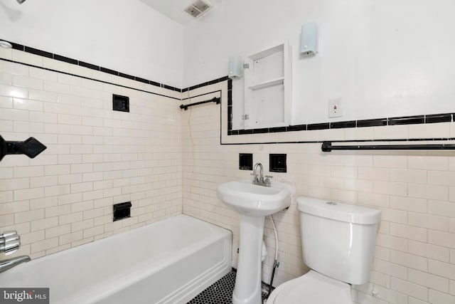full bath with tile walls, toilet, bathing tub / shower combination, and visible vents