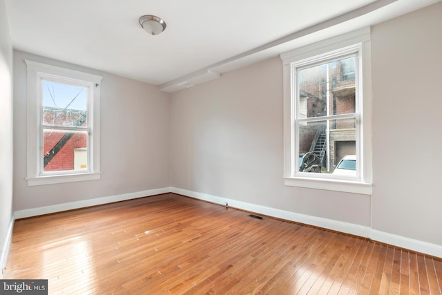 spare room with light wood-style floors and baseboards