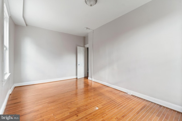 empty room with baseboards and light wood-style floors