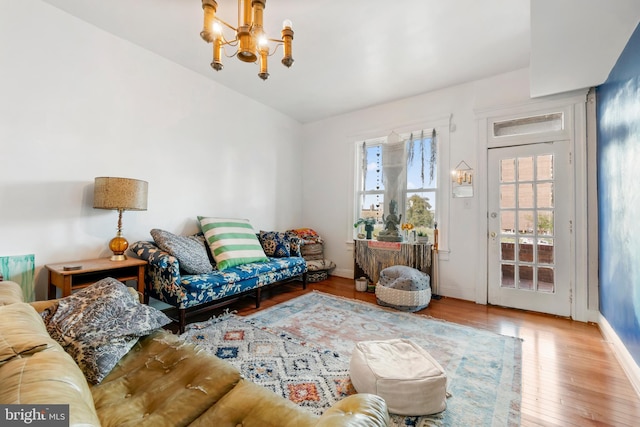 living room featuring baseboards, wood finished floors, and a chandelier