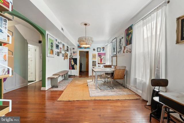 dining room featuring baseboards, an inviting chandelier, and hardwood / wood-style floors