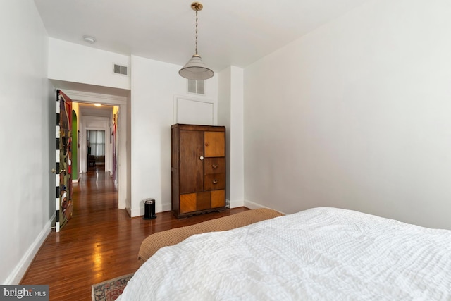 bedroom featuring dark wood-style flooring, baseboards, and visible vents