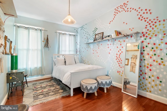 bedroom featuring baseboards, wood-type flooring, and wallpapered walls