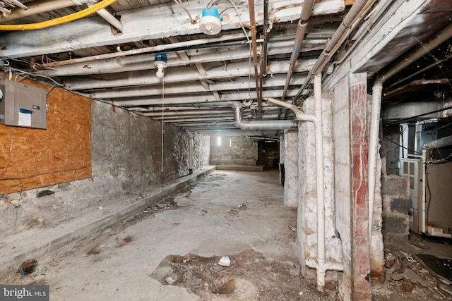unfinished below grade area with heating unit and electric panel