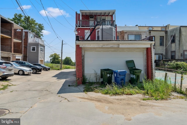 exterior space featuring brick siding, fence, and a garage