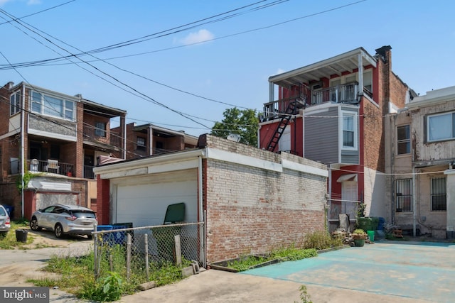 view of property exterior featuring brick siding, fence, and a garage