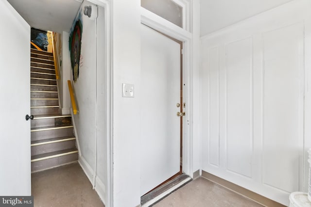 entryway with stairs and concrete flooring