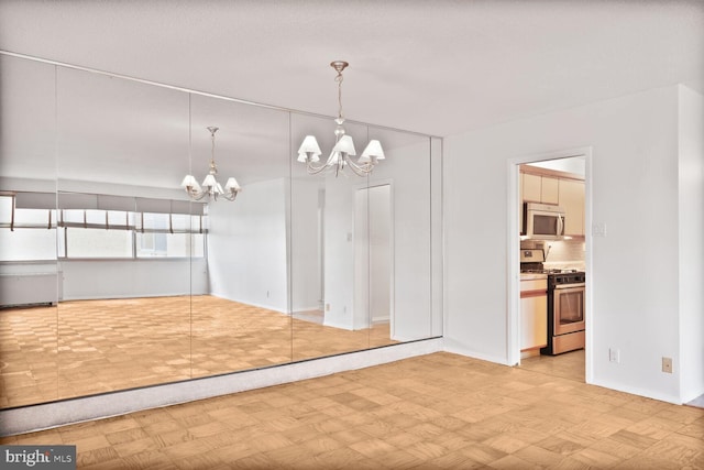 unfurnished dining area featuring an inviting chandelier, light floors, and baseboards