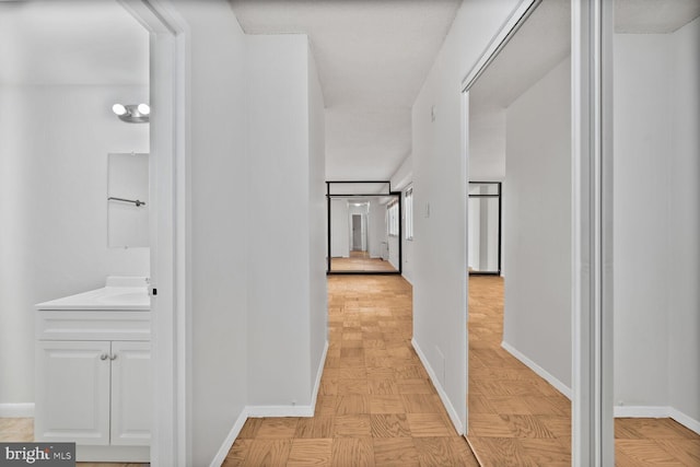 hall with baseboards and a sink