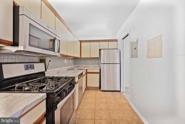 kitchen featuring electric panel, light countertops, stainless steel appliances, and a sink