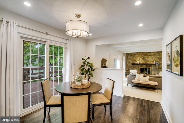 dining room with dark wood-style flooring, baseboards, recessed lighting, a chandelier, and a fireplace