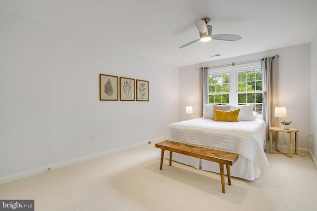 bedroom featuring light colored carpet, baseboards, and a ceiling fan