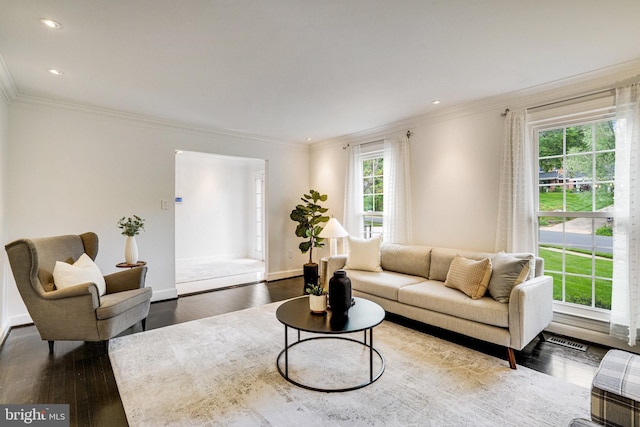 living room featuring dark wood-style flooring, crown molding, baseboards, and recessed lighting