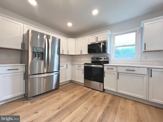 kitchen featuring appliances with stainless steel finishes, light countertops, light wood-style floors, recessed lighting, and white cabinetry