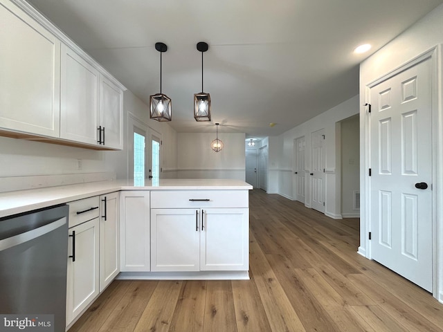 kitchen with light wood-style floors, stainless steel dishwasher, a peninsula, and white cabinetry