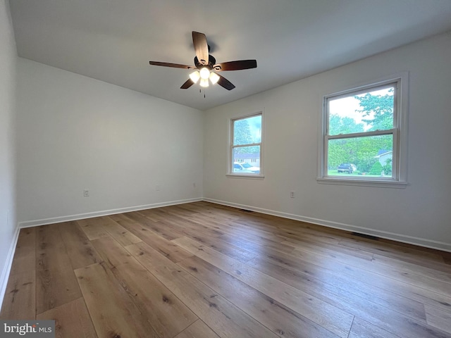 unfurnished room with ceiling fan, baseboards, and hardwood / wood-style flooring