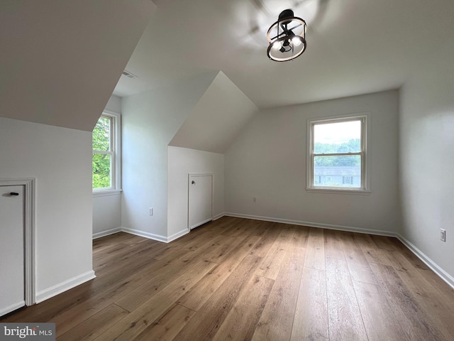 bonus room featuring wood-type flooring, baseboards, and vaulted ceiling