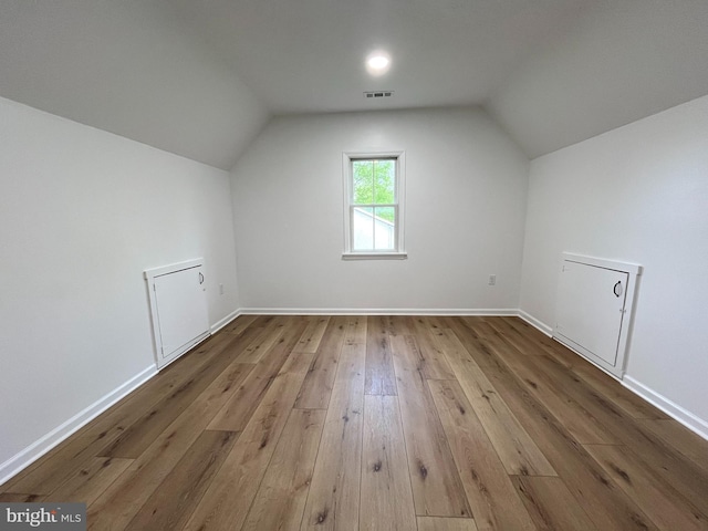 bonus room featuring baseboards, vaulted ceiling, hardwood / wood-style flooring, and visible vents