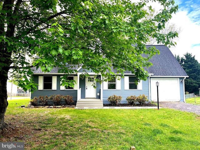 view of front of house featuring an attached garage, gravel driveway, roof with shingles, and a front yard