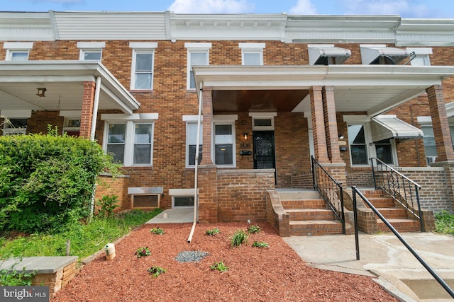 view of front facade featuring covered porch and brick siding