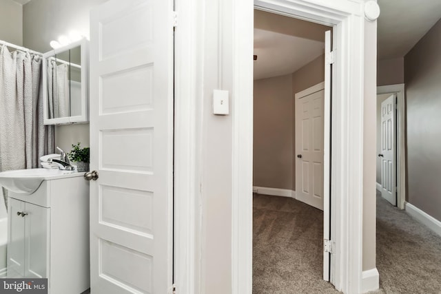 interior space featuring vanity, baseboards, and curtained shower