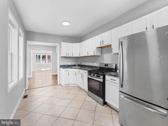 kitchen with white cabinets, dark countertops, appliances with stainless steel finishes, baseboards, and visible vents