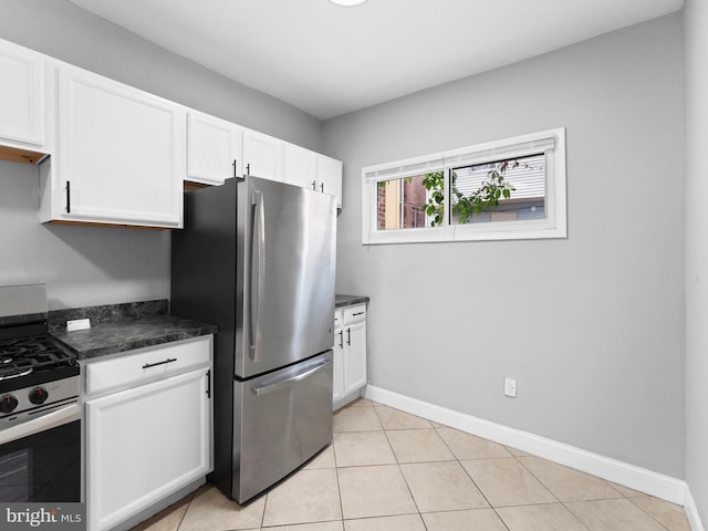 kitchen featuring baseboards, appliances with stainless steel finishes, light tile patterned flooring, and white cabinets