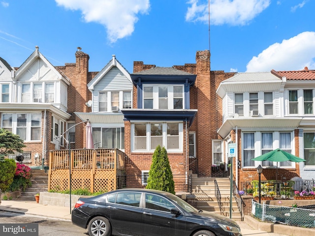view of front of property featuring stairs and brick siding