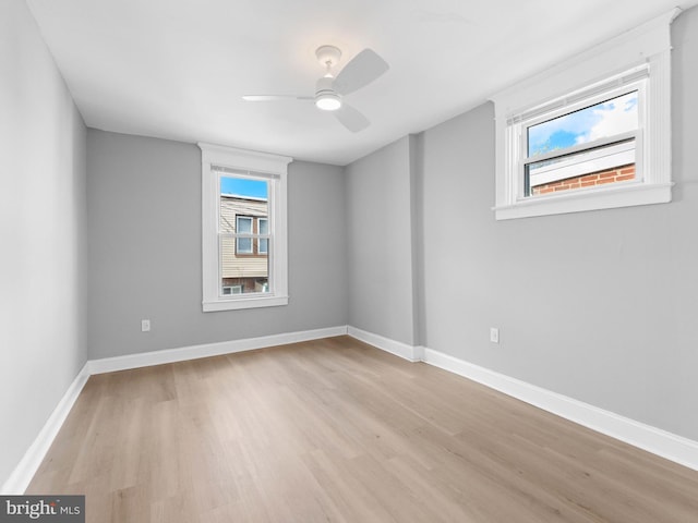 unfurnished room featuring a ceiling fan, baseboards, and light wood-type flooring