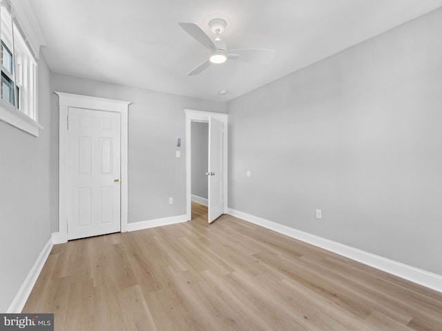 unfurnished bedroom featuring light wood-style floors, a ceiling fan, and baseboards