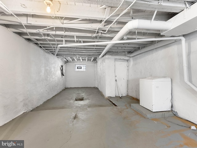 below grade area featuring refrigerator