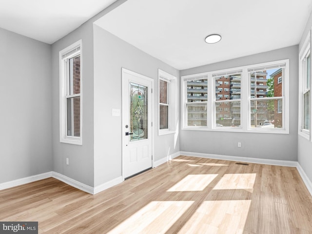 foyer featuring baseboards, visible vents, and light wood-style flooring