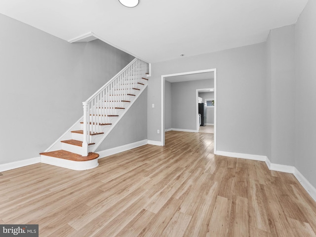 interior space with baseboards, stairs, and wood finished floors