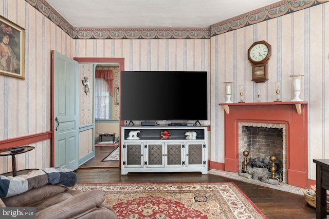 living room with a fireplace with flush hearth, dark wood-style flooring, and wallpapered walls
